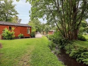 温德米尔Tiggywinkle Beck Lodge的小木屋,带院子和树