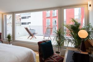 波尔图Almadina Smart Luxury的一间卧室配有一张床,阳台配有椅子