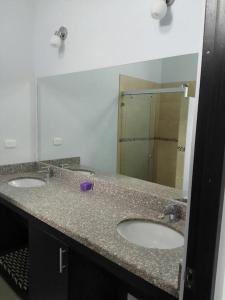 塔马林多Playa Tamarindo, CasaMar de Tamarindo的一间带两个盥洗盆和大镜子的浴室