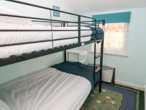 纳伯斯10 Llanteglos Estate的一间卧室设有两张双层床和一扇窗户。