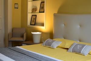 塔兰托queen 24的一间卧室配有带2个枕头和椅子的床