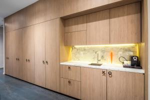 迈阿密Suites at SLS Lux Brickell managed by CE的一个带木制橱柜和水槽的厨房