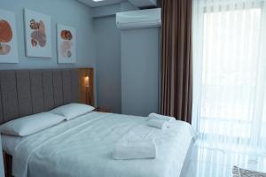 萨潘贾Didi Butik Hotel的一间卧室配有一张床,上面有两条毛巾