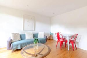 伦敦Spacious 1 Bedroom Apartment in Vibrant Angel的客厅配有蓝色的沙发和红色的椅子