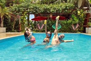 科苏梅尔Hotel Villas Colibrí Suites & Bungalows的3人在游泳池里玩飞盘