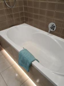 科沙林Apartament Lux的白色浴缸,上面有蓝色的毛巾