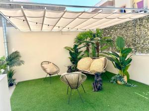 吉亚德伊索拉CASA SOLE - Apartamento Playa San Juan NR. 4的天井配有两把椅子、桌子和草地