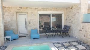 帕诺尔莫斯雷斯蒙Zefyros Suite , Seafront retreat !的一个带桌椅的庭院和一个游泳池