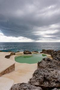 尼格瑞尔庭阁雷亚度假旅馆的靠近海洋的岩石上的高尔夫球场