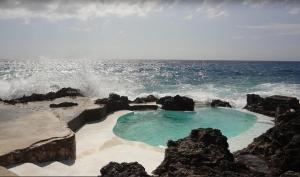 尼格瑞尔庭阁雷亚度假旅馆的岩石海滩上的一个小水池