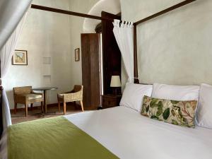 亨达波萨达拉斯特拉姆帕斯精品酒店的一间卧室配有一张床和一张桌子及椅子