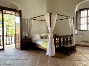 亨达波萨达拉斯特拉姆帕斯精品酒店的一间卧室设有一张天蓬床和一个阳台