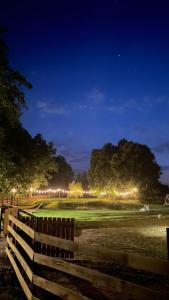 鲁恰内尼达Wypoczynek pod Lipami的夜间在田野里用灯光围起来的栅栏