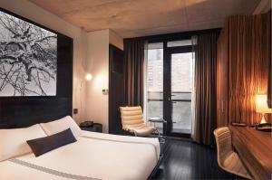 纽约瑟斯提莱斯酒店的一间卧室配有一张床和一个带椅子的窗户