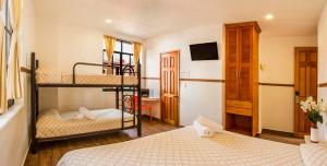 墨西哥城特姆普罗市长酒店的一间卧室配有两张双层床和一张书桌