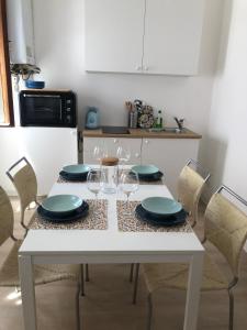 梅斯特Casa Mestrina的厨房配有带盘子和酒杯的白色桌子