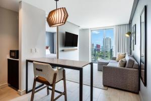 迈阿密Atwell Suites - Miami Brickell, an IHG Hotel的客厅设有餐桌和沙发