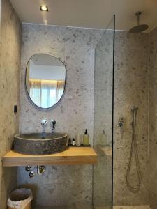 库基尼坎尼奥Mira Living Concept Suites Adults Only的浴室配有盥洗盆和带镜子的淋浴