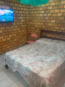 康德Cifa & Alê Hospedaria的一间卧室设有一张床和砖墙