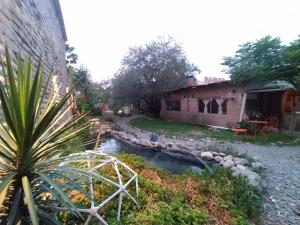 卡法亚特Casa Arbol Domos的一座花园,旁边是一条小溪