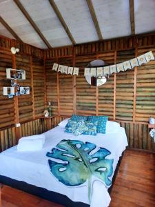 San Antonio del TequendamaLa Guarida eco-posada的木制客房内的一间卧室,配有一张床