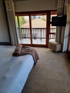 范德拜尔帕克Emufuleni river logde的一间卧室设有一张床,享有阳台的景色