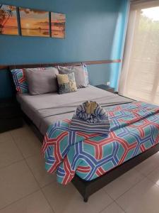 塔马林多Playa Tamarindo, CasaMar de Tamarindo的蓝色墙壁间的一张床位