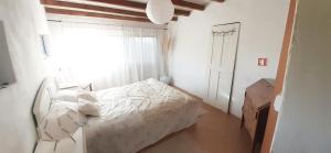 Casa da Abelha- Beehouse的一间卧室配有一张带白色床单的床和一扇窗户。
