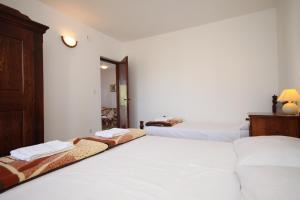 斯塔利格拉德-帕克利尼卡Apartment Starigrad 6647a的白色墙壁客房的两张床