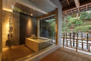 神户有马温泉 竹取亭丸山温泉旅馆的一间带大窗户和浴缸的浴室