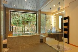 神户有马温泉 竹取亭丸山温泉旅馆的带浴缸的浴室和大窗户