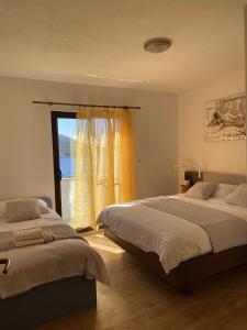 UbliApartments by the sea Ubli, Lastovo - 8344的一间卧室设有两张床和窗户。