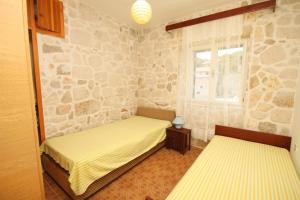 拉斯托伏Seaside holiday house Lucica, Lastovo - 8348的石墙客房的两张床