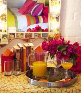 迪韦齐斯老磨房住宿加早餐旅馆的桌上的橙汁和书籍托盘