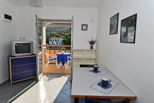 UbliApartments by the sea Pasadur, Lastovo - 8351的客厅配有桌子和电视