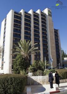 耶路撒冷Jerusalem Gardens Hotel的两个人站在一个大建筑前