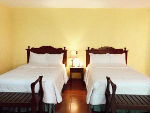 圣萨尔瓦多维拉特拉酒店的配有两张床垫的酒店客房内的两张床