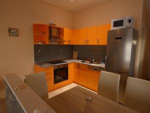 UbliApartments by the sea Ubli, Lastovo - 8354的厨房配有橙色橱柜和不锈钢冰箱