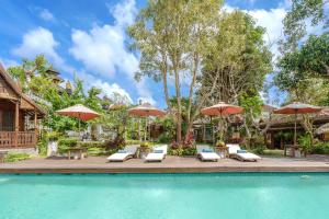 乌鲁瓦图My Dream Bali的一个带躺椅和遮阳伞的游泳池