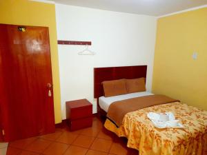 万卡约Hospedaje Las Lilas的卧室,卧室配有一张床,卧室位于带门的房间