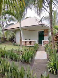 Lawa-anJupiters Garden Cottages的前面有棕榈树的房子