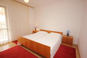 Donje SeloApartments by the sea Muline, Ugljan - 8520的卧室配有一张白色大床和红色地毯。