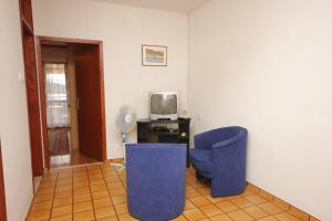 Donje SeloApartments by the sea Muline, Ugljan - 8520的客厅配有2把蓝色椅子和电视