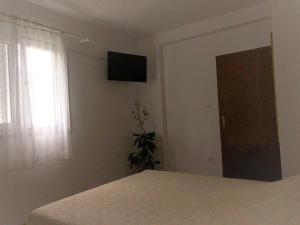 斯拉诺Apartments by the sea Slano, Dubrovnik - 8599的卧室配有一张床,墙上配有电视