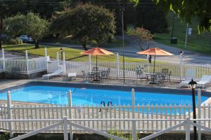 Brewster海蒂旅馆的一个带桌椅和遮阳伞的游泳池