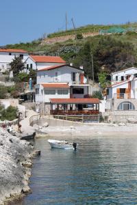 ZaračeApartments by the sea Cove Zarace - Dubovica, Hvar - 8778的房屋旁边的水中的小船