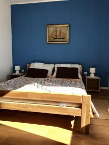 维甘Holiday house with a parking space Viganj - Podac, Peljesac - 10141的一间卧室设有一张蓝色墙壁的大床