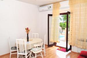 苏佩塔尔Seaside apartments with a swimming pool Supetar, Brac - 11360的一间带桌椅和窗户的用餐室