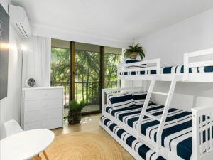 黄金海岸The Rocks Resort - Official的一间卧室配有双层床、一张桌子和一张桌子