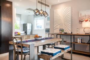 卡伦海滩Karon Sea View Beach Apartment的厨房以及带木桌和椅子的用餐室。